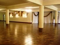 Interior of the F&R Party Hire function venue with draped windows and a tiled floor